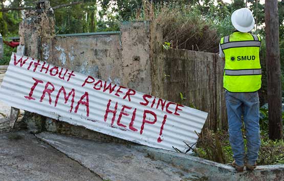 SMUD tus neeg ua haujlwm nyob rau pem hauv ntej ntawm lub cim uas hais tias, 'Tsis muaj hwj chim txij li Irma pab!'
